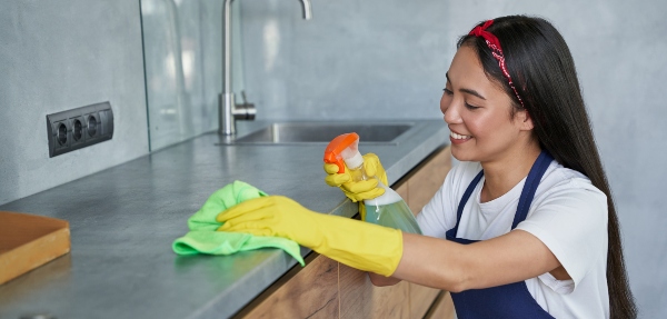 Woman cleaning a kitchen countertop